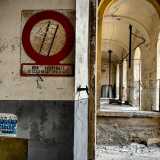 ...svelando cos� lunghi silenziosi padiglioni, rari macchinari e poi scritte, cartelli e giornali risalenti a quasi mezzo secolo fa